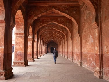 Long corridor inside Bara Imambara in Lucknow, arched ceiling receding into natural diffused daylight, a lone visitor walking the stone floor, warm ochre walls on either side