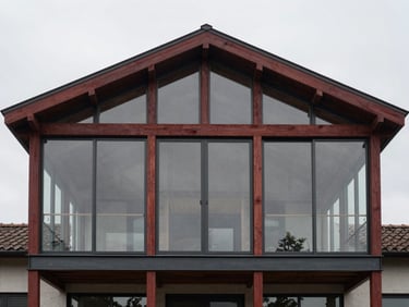 Symmetrical architectural shot of a structural residential extension, steel frame integrated with bespoke timber beams, soft overcast daylight through large glass panes, 35mm lens.
