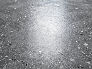 Extreme close-up of a polyurea floor texture with gray and white flakes, satin finish, sharp focus on the slip-resistant texture