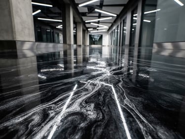 Low-angle macro shot of a glossy carbon black epoxy floor with metallic silver veins, reflecting bright overhead studio light, sharp architectural details