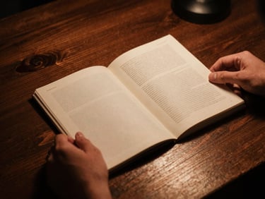Close-up of hands holding a vintage printed independent zine on a dark wooden table, warm copper spotlight, moody shadows, authentic analog grain.