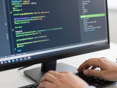 A close-up of hands typing code on a monitor, reflecting lines of clean code, focus on software development, professional technology photography, bright natural daylight, crisp navy and green accents, sharp focus, 35mm.