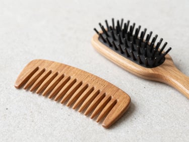 Premium wooden combs and natural hair brushes on a clean stone surface, soft diffused light