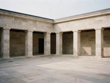 Editorial architectural photography of a quiet, sunlit stone courtyard with clean geometric lines, soft overcast daylight, desaturated earth tones, medium format film.