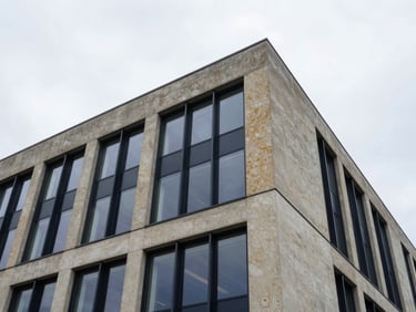 Architectural details of a modern commercial concrete and glass structure, looking up, overcast sky, sharp focus