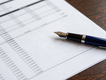 Tight macro detail of heavy paper stock financial reports and a fountain pen on a dark wood desk, sharp focus, 35mm