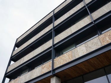 Low-angle architectural detail of a modern steel and concrete commercial building facade under a bright overcast sky, sharp focus, 35mm