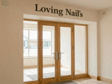 Warm wide-angle photograph of the Loving Nail's Spa entrance, soft cream-and-wood interior visible through clean glass doors, gentle natural window light, inviting and serene
