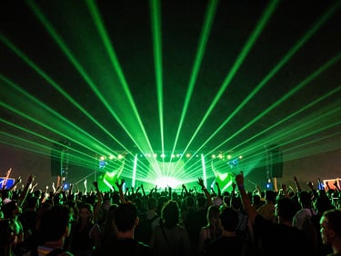 Massive crowd dancing at an EDM music festival with intense green lasers and strobe lights, low-angle, motion blur