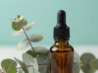 Close-up of a clean amber glass dropper bottle next to fresh eucalyptus leaves, soft natural daylight, clinical teal background