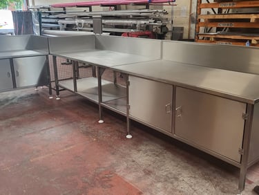 Custom industrial stainless steel prep tables and storage cabinets for commercial kitchens.