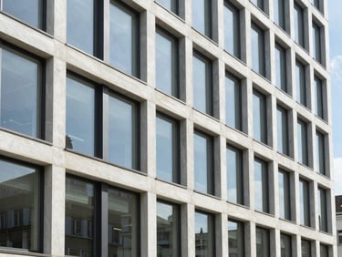 Modern Swiss architectural details, clean glass facade of a commercial building in Zurich, bright natural daylight, sharp focus.