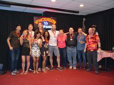 a group of people standing around a table with medals
