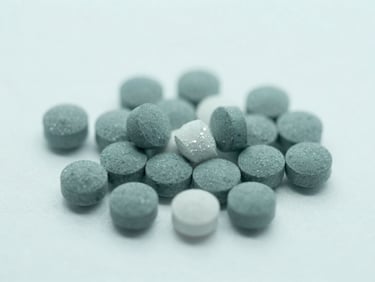 Macro shot of crystalline pharmaceutical compounds on a clean white backdrop, cool diffused laboratory light, sterile teal tones