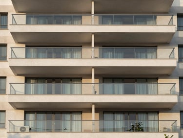 Modern apartment facade in Guarulhos, clean lines, large glass balconies, soft morning light, 35mm lens.