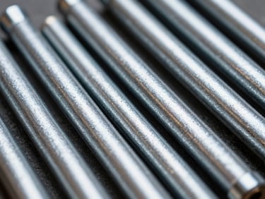 Close-up macro shot of freshly zinc-plated industrial parts, showing a smooth, uniform, and bright metallic surface under high-contrast industrial lighting, cool metallic tones.