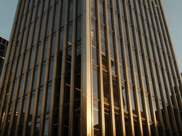Dramatic exterior elevation of a modern corporate high-rise, gold-accented steel grid facade, high-contrast architectural lighting.