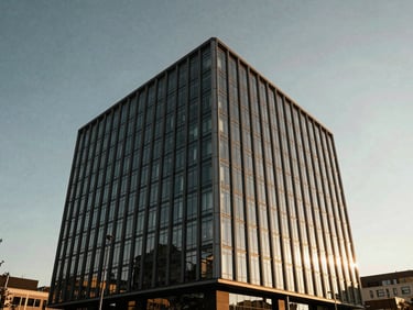 Crisp daylight architectural photo of a modern glass and steel medical tower, clean geometric lines, high-contrast sky.