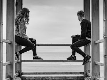 a man and woman sitting on a bench in a doorway