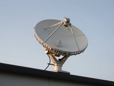 Wide-angle shot of a Starlink dish mounted on a roof bracket, clear sky behind, cable run descending along fascia, natural daylight on white dish hardware