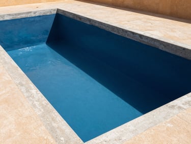 Clean indoor shot of a swimming pool concrete shell coated in a blue cementitious waterproofing slurry, sharp architectural lines.