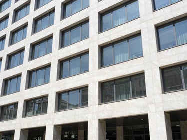 Bright corporate photography of a modern multi-finance building facade, clean natural daylight