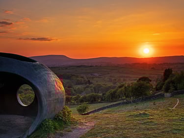 a sunset over a hill with a large circular shape: the wycoller atomd object