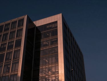 Architectural detail of a modern corporate building in Mazatlán, sharp geometric lines, steel and glass reflecting a deep twilight sky, 35mm.