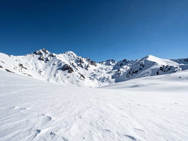 Panoramic high-altitude view from Valle Nevado, snow fields in the foreground, jagged Andean peaks receding into a cobalt sky, midday light, no people, vast scale