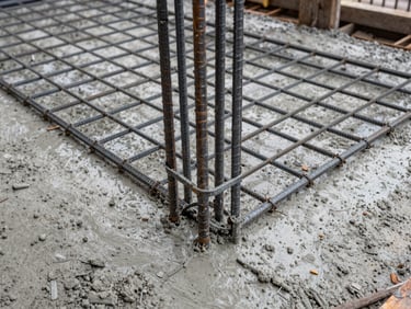 Close-up overhead shot of freshly poured concrete with rebar grid visible, natural overcast daylight, construction site surface, no people