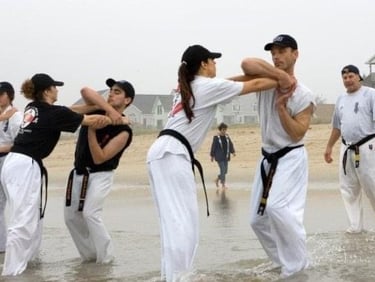 a group of people standing in the water practicing self defence