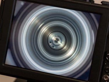 Macro shot of a high-resolution diagnostic camera screen showing a completely clear pipe interior, bright lighting.