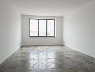 Interior living room of a modern flat in Cerdanyola del Vallès, white walls, polished concrete floor, large window with daylight, no people, no staging clutter