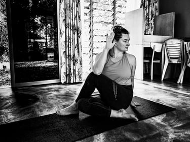 A woman performs a yoga pose - Ardha Matsyendrasana, or Half Lord of the Fishes Pose,