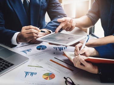 a group of people sitting at a table with laptops and laptops