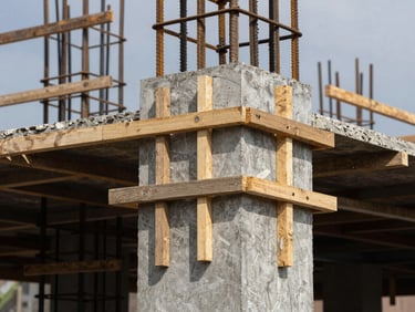 Close-up of reinforced concrete column formwork being assembled on a Cameroonian building site, daylight, precise timber bracing visible, no workers posing