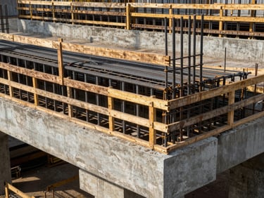 Detail of reinforced concrete bridge abutment formwork under construction in Cameroon, daylight, precisely aligned steel rebar cage visible through timber form gaps