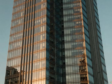 Low-angle architectural detail of Port Baku Towers glass facade during golden hour, sharp reflections