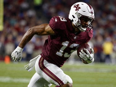 Dynamic close-up shot of a football player sprinting with the ball, high-contrast stadium lighting, saturated colors