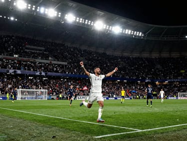 Dynamic sports photography, high-contrast stadium lighting, a soccer player celebrating a goal in front of a massive blurry crowd, intense green turf reflections, wide angle.
