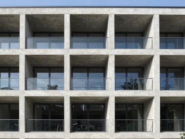 Straight-on architectural elevation of a modern concrete building under bright daylight, crisp shadows, clean structural lines, 35mm