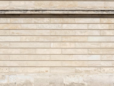 Wide-angle architectural shot of a restored stone facade in Paris, clean structural lines, bright daylight