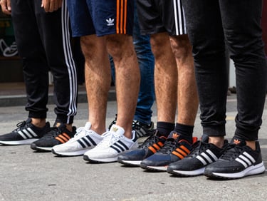 Low-angle shot of Adidas Originals apparel and sneakers worn on street, urban Vietnam