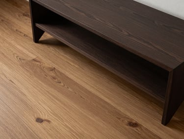 Top-down detail shot of minimalist dark wood furniture resting on scratch-resistant premium oak SPC flooring in a spacious Shah Alam bungalow.
