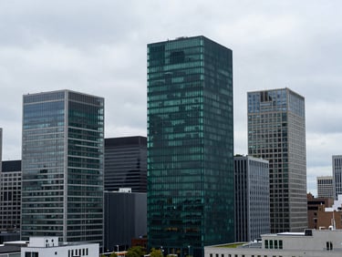Modern architectural integration of green tech in a city skyline, natural overcast daylight, cool slate and deep emerald tones, wide-angle lens, realistic
