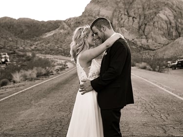 a bride and groom kissing on the road