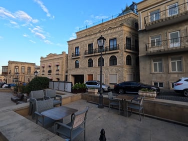 a table with chairs and chairs in front of a building