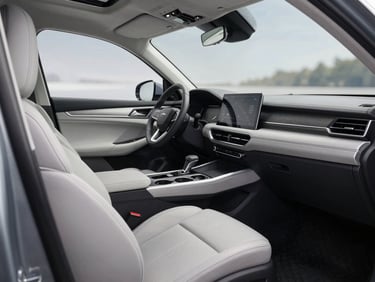Interior cabin shot of a grey mid-size SUV showing dashboard and front seats under showroom daylight, clean upholstery