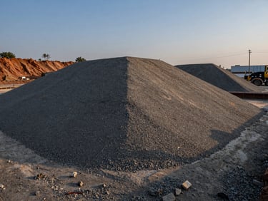 Coarse sub-base material laid out on an infrastructure site, twilight lighting