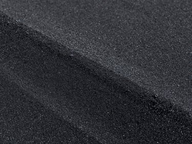 Coarse dark industrial black sand, high contrast lighting, sharp focus